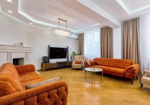 Una sala de estar con dos sofás y un televisor. en Penthouse in Vake, en Tiflis