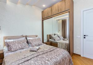 Un dormitorio con una cama y un espejo grande. en Penthouse in Vake, en Tiflis
