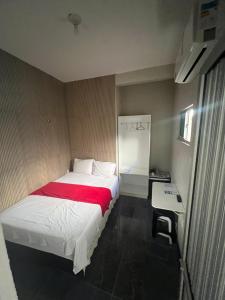 a bedroom with a bed with a red blanket at Pousada da Celma in Fortaleza
