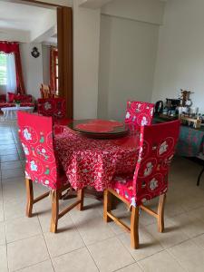stół jadalny i krzesła z czerwoną tkaniną w obiekcie Palanca Lodging Home w mieście Candelaria