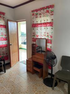 Habitación con escritorio, silla y espejo. en Palanca Lodging Home en Candelaria
