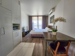 a living room with a bed and a dining room table at Exodus Dandenong Apartment Hotel in Dandenong