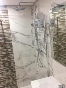 Un baño con ducha, lavabo y espejo. en Casa Emperador Penthouse, en Roldán