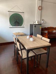 a dining room table with chairs and a table and a clock at Freedom8 in Khlong San