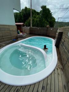 a person swimming in a jacuzzi tub on a deck at Siri Mariscal Bombinhas C Piscina in Bombinhas