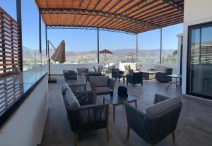 a living room with couches and tables and windows at Hotel Blanco Pachuca in Pachuca de Soto