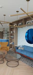 a living room with a blue couch and two tables at Azure North San Fernando Pampanga in San Fernando