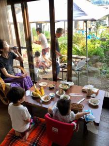 un grupo de personas sentadas alrededor de una mesa con comida en Big loghouse - Vacation STAY 13327, en Ogano