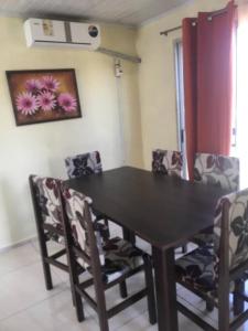 uma sala de jantar com uma mesa preta e cadeiras em N8 Casa 2 Dorm Zona Residencial Barrio Villa Lola Artigas em Artigas