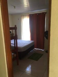 um pequeno quarto com uma cama e uma janela em N8 Casa 2 Dorm Zona Residencial Barrio Villa Lola Artigas em Artigas