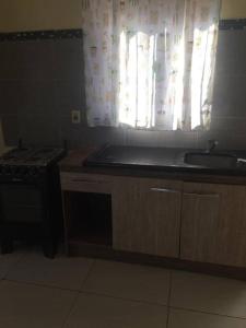 a kitchen with a sink and a stove and a window at N8 Casa 2 Dorm Zona Residencial Barrio Villa Lola Artigas in Artigas