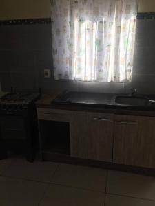 eine Küche mit einem Waschbecken und einem Fenster in der Unterkunft N8 Casa 2 Dorm Zona Residencial Barrio Villa Lola Artigas in Artigas