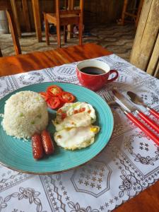 einen Teller mit Reis und Tomaten und eine Tasse Kaffee in der Unterkunft Southpoint Hostel in Moalboal