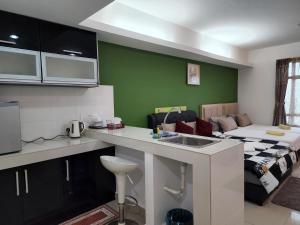 uma cozinha com um lavatório e uma sala de estar em The Viana Apartment 3 em Kota Bharu