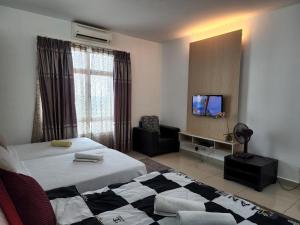 a hotel room with two beds and a television at The Viana Apartment 3 in Kota Bharu