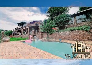 a swimming pool in front of a house at Va sabi bo, luxury family living in Hartbeespoort Dam in Hartbeespoort