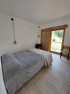 1 dormitorio con 1 cama y puerta corredera de cristal en Casa Arbet - Villa 25 de Mayo, San Rafael, Mendoza en San Rafael