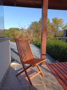 a wooden rocking chair sitting on a porch at loft interno in Villa General Belgrano