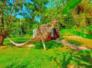a hammock in front of a cabin in the woods at Hotel Jasayma dentro del Parque Tayrona in El Zaino