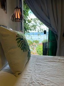 1 dormitorio con cama con almohada y ventana en Casa aluguel ilha grande,Mar 2, en Abraão
