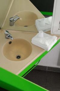 a bathroom counter with a sink and a mirror at Lemon Hotel - Tourcoing in Tourcoing