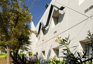 - un bâtiment blanc avec des fenêtres sur le côté dans l'établissement Lemon Hotel - Tourcoing, à Tourcoing