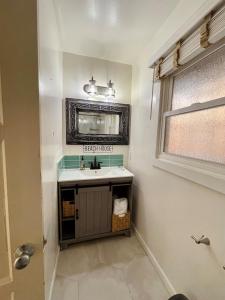 a bathroom with a sink and a mirror at OCEAN FRONT Beach HOUSE! Private Stairs to SAND! in Laguna Beach