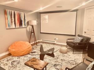 a living room with a projection screen and a chair at Cedar Mill Hideaway in Woodbury