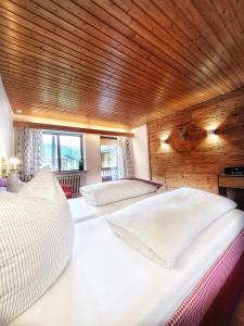 2 camas en una habitación con techo de madera en Gästehaus Waldrast en Ramsau