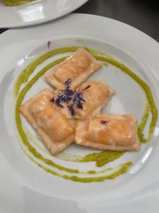 Un plato blanco con tres trozos de comida. en Albergo Ristorante Giuliana en Guarcino