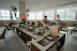 a buffet line in a restaurant with people in the background at Portola Grand Renggali Hotel Takengon in Takengon
