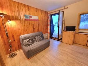 salon z krzesłem w pokoju z drewnianymi ścianami w obiekcie Studio 4 Pers avec Terrasse et Jardinet - Ski et Randos à Pied - Animaux Admis - FR-1-393-164 w mieście Saint-Michel-de-Chaillol