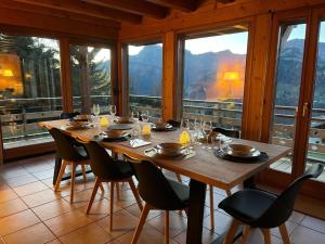 a dining room with a table and chairs and windows at Chalet Crest-Voland, 7 pièces, 8 personnes - FR-1-505-181 in Crest-Voland