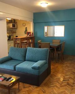 sala de estar con sofá azul y cocina en San Telmo Heart en Buenos Aires