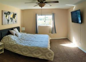 a bedroom with a bed and a ceiling fan at Villa Luhna 3 Bed / 2 Bath Canalfront Heated Pool in Cape Coral +14 photos