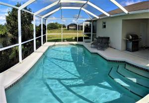 a swimming pool with a pergola over it at Villa Luhna 3 Bed / 2 Bath Canalfront Heated Pool in Cape Coral