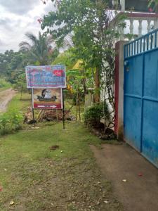 a sign in the grass next to a house at Casa de Corazon in Kandabong