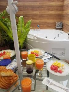 a glass table with breakfast foods and a bath tub at MALU HOUSE - PERU - Lima in Lima