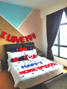 a bedroom with a bed with a i love you sign on it at Comfy Imperium Residence Kuantan Studio Seaview in Kuantan