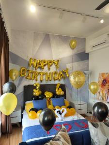 Comfy Imperium Residence Kuantan Studio Seaview في كُوانتان: غرفة نوم بسرير وبالونات وعلامة عيد ميلاد سعيد