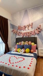Una cama con un feliz cartel de Año Nuevo. en Comfy Imperium Residence Kuantan Studio Seaview en Kuantan