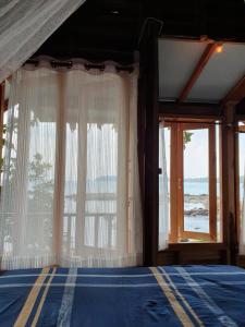 a bedroom with a bed and a large window at Palm Beach Resort Koh Phayam in Ko Phayam