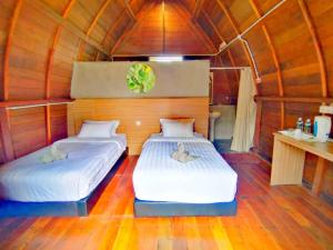 2 letti in una camera con pavimenti in legno di Ovai Hidden Paradise Resort a Papar