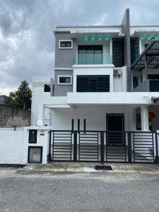 a white house with a fence in front of it at A Home - Homestay near St Anne Church Bukit Mertajam in Bukit Mertajam