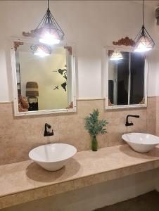 a bathroom with two sinks and two mirrors at Dolores Residences Rm Bianca in General Santos