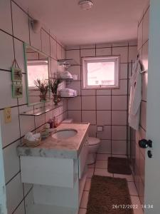 a bathroom with a sink and a toilet and a window at apartamento na praia de Iracema com vista mar in Fortaleza