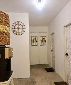 a room with a clock on the wall and two doors at Dolores Residences Rm Bianca in General Santos