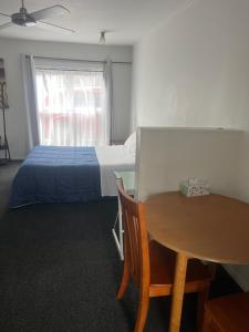 1 dormitorio con cama, mesa y sidx sidx sidx de mesa en K&R Orewa homestay, en Orewa