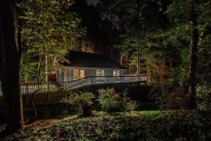 a house in the middle of a forest at night at Misty Mountain Hop - Cobbly Nob Cabin with HotTub, Fast Wi-Fi, Privacy, Pool in Gatlinburg