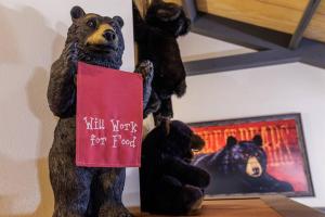 uma estátua de urso segurando um sinal que lê "matar palavras para comida" em Misty Mountain Hop - Cobbly Nob Cabin with HotTub, Fast Wi-Fi, Privacy, Pool em Gatlinburg